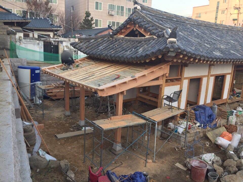 뼈대 위로 처마와 지붕틀을 다시 올리는 모습